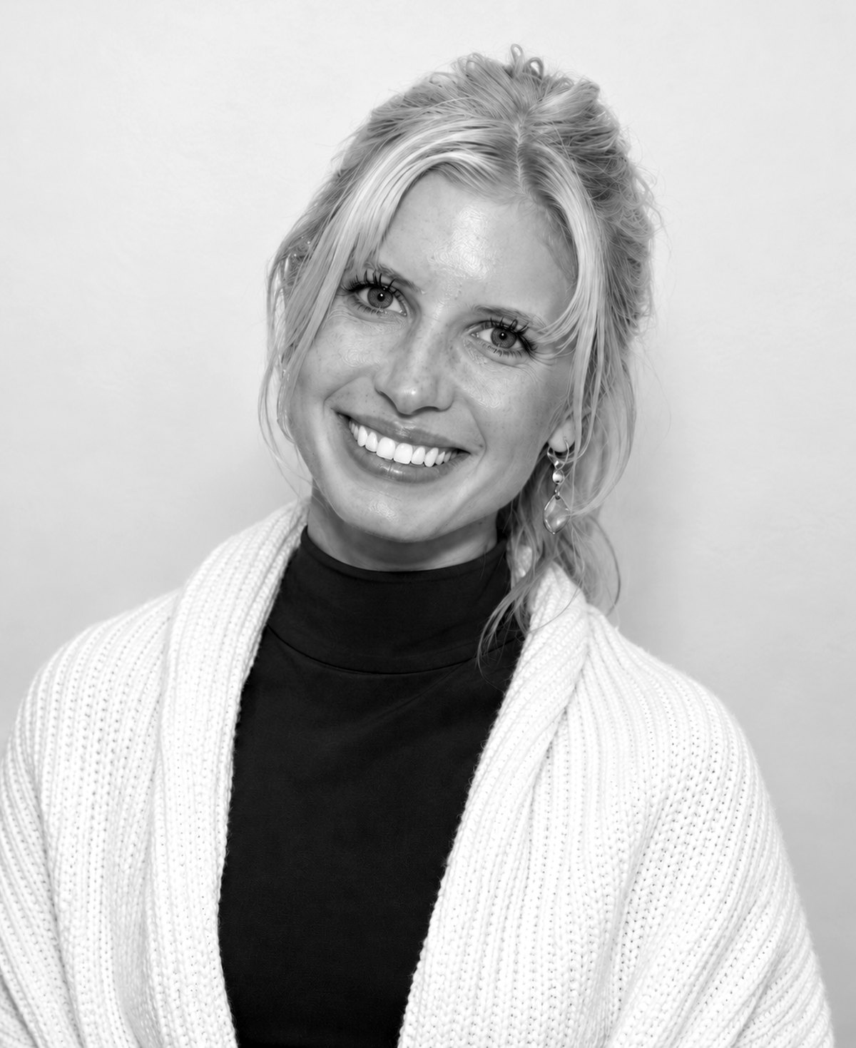 Greta Hirschfeld, black and white portrait, smiling at the camera.